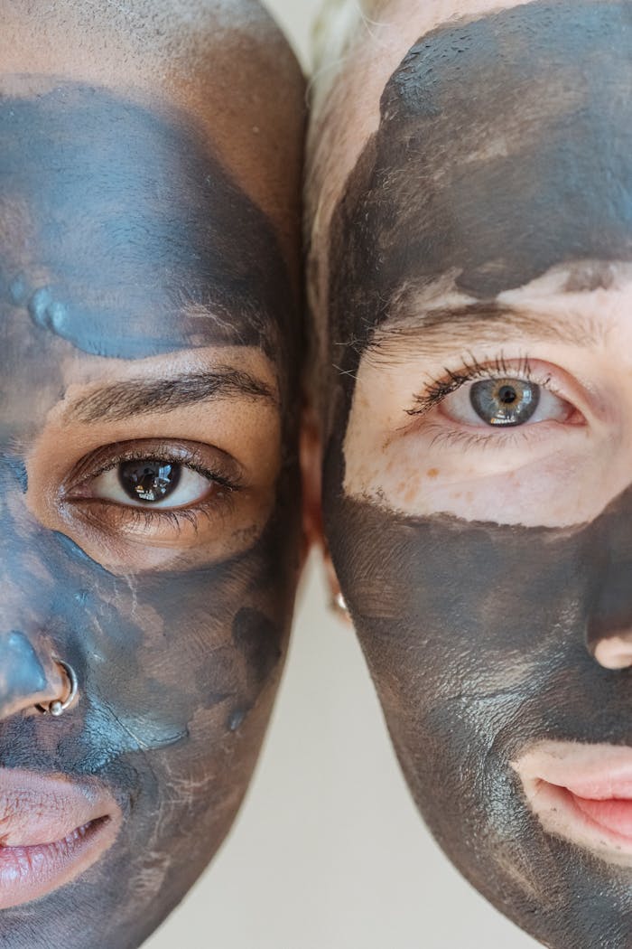 Multiracial women with clay mask looking at camera